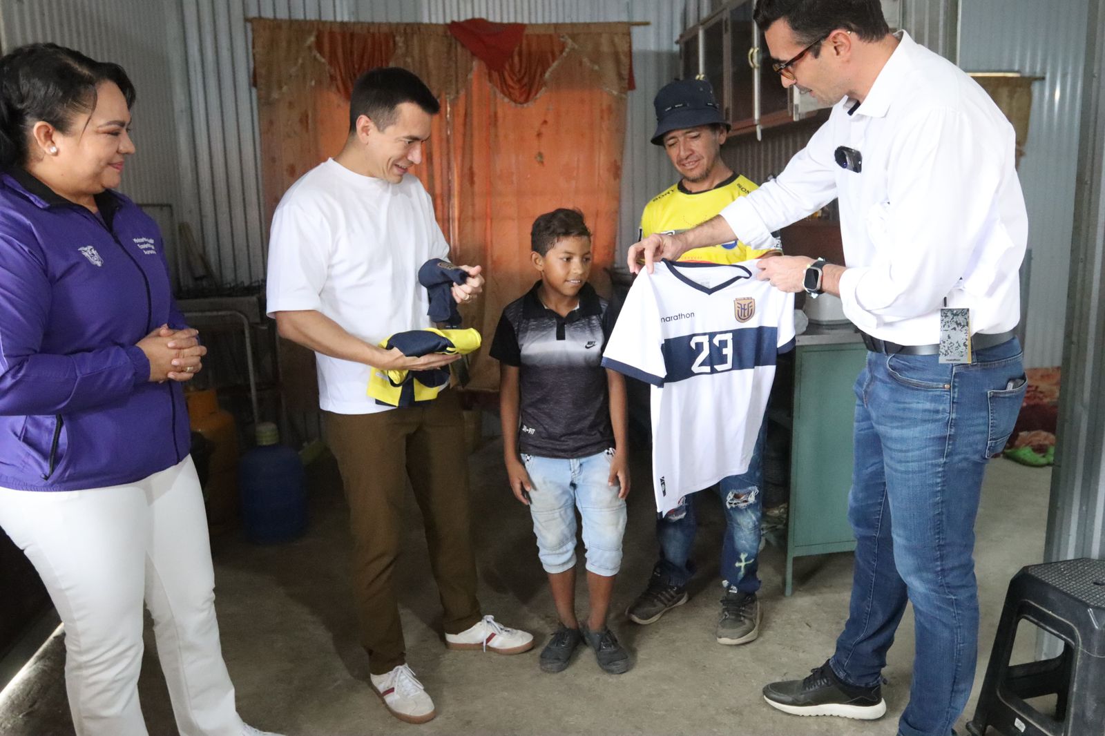 Directora del MIES, Aurora Valle, ministro Andrés Guschmer, y Presidente Daniel Noboa, entregan bono a padre viudo y su hijo