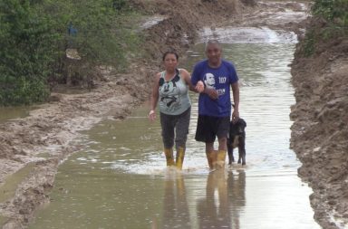 Lorenzo Pico y su esposa Beatriz Lucas caminan por una calle inundada.